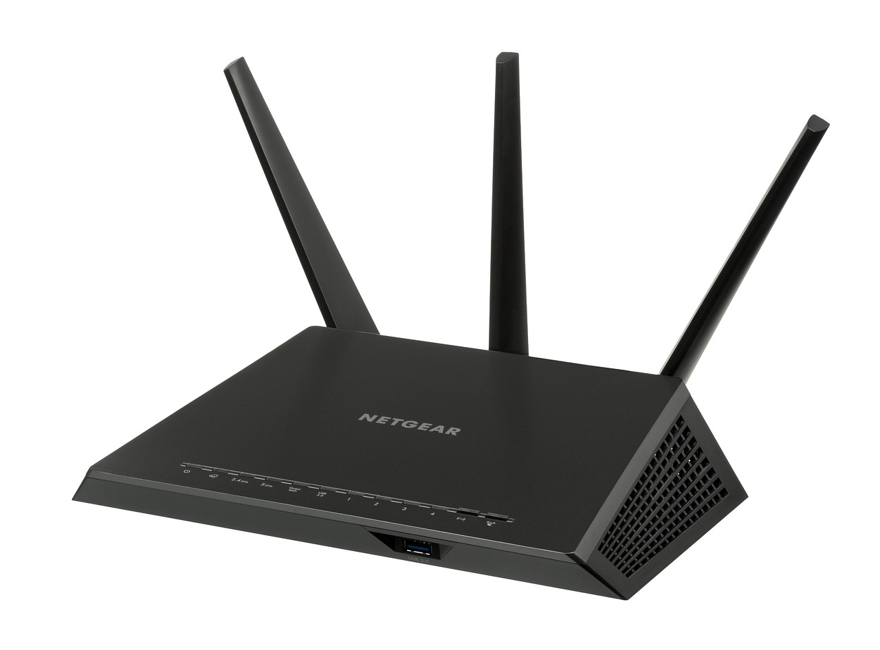 Czarny router Wi-Fi z trzema antenami ustawiony na jasnym tle.