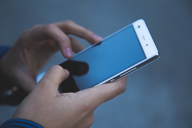Osoba trzyma telefon w dłoniach
